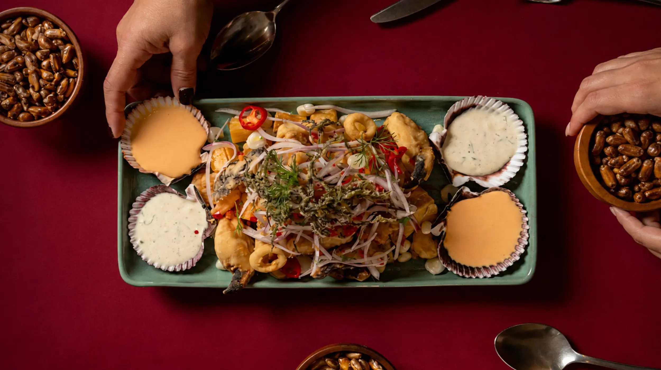 Jalea de mariscos de Pescados Capitales servida con salsa criolla, conchas y cremas de la casa en restaurante peruano de Lima.
