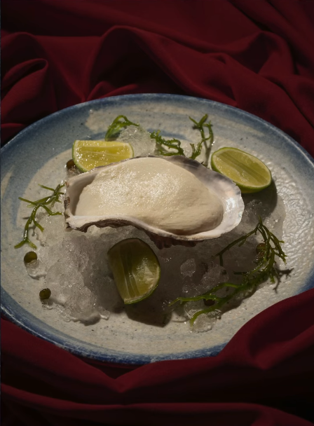 Ostra fresca servida sobre hielo con limones y algas en Pescados Capitales, especialista en pescados y mariscos frescos.
